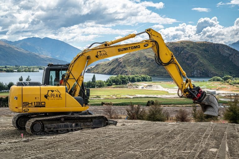 SH130 excavator working on site with Wanaka mountain backdrop