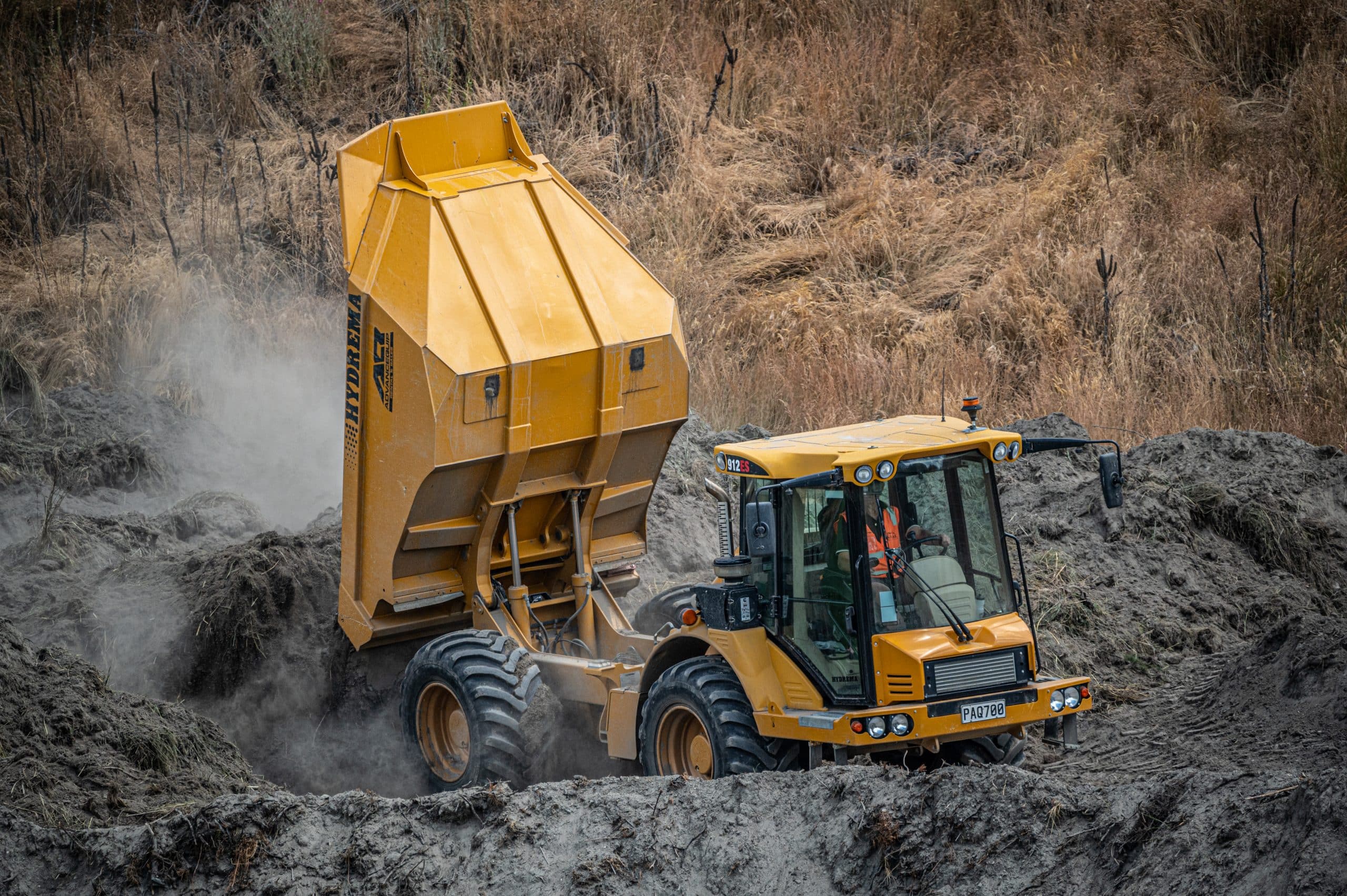 Hydrema earthmoving truck creating soil stockpile for golf course project NZ